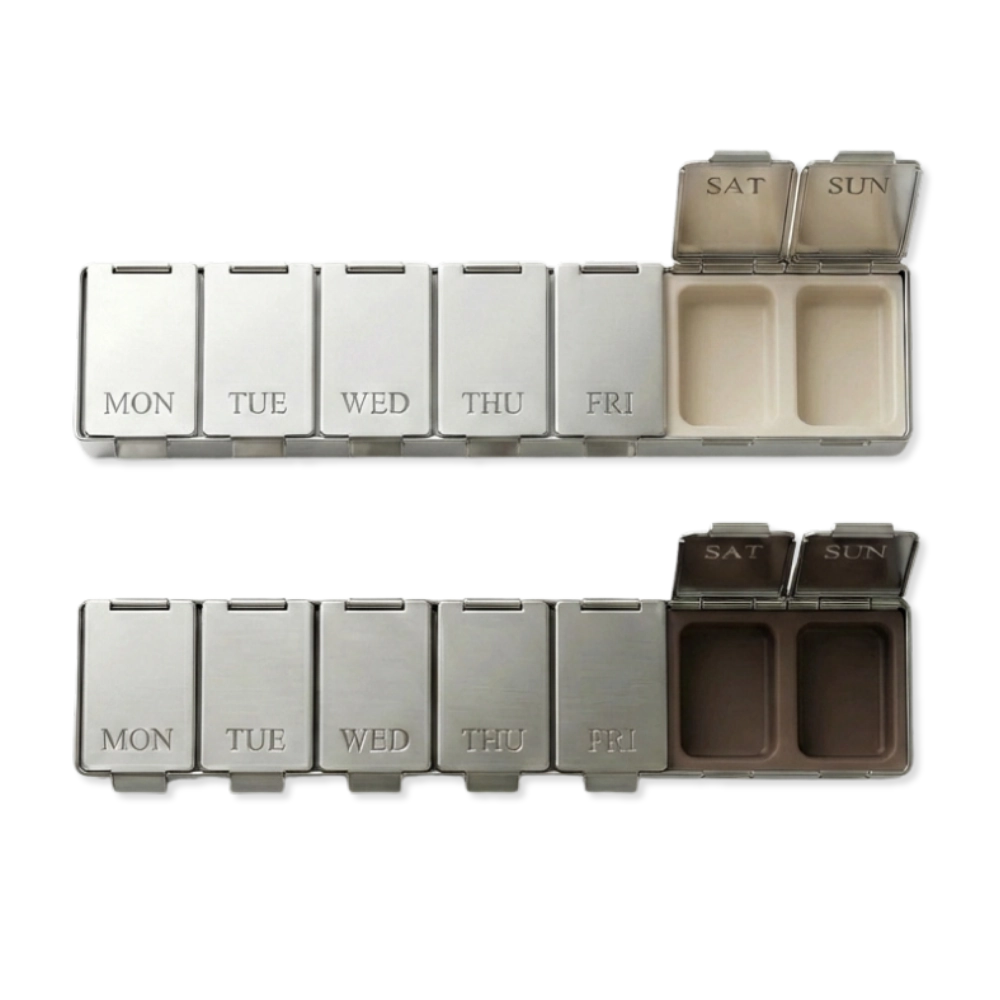 Zwei geöffnete DOSE & DONE Wochen-Pillendosen in creme und braun mit beschrifteten Tagesfächern auf transparentem Hintergrund.